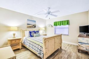 una camera con letto e ventilatore a soffitto di Cocoas By The Sea a Cocoa Beach Altre 30 foto
