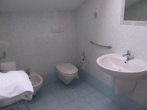 a white bathroom with a sink and a toilet at Le antiche Torri in Pescasseroli