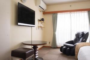 Habitación de hotel con cama, mesa y TV. en Outlet Hotel UenoEkimae en Tokio