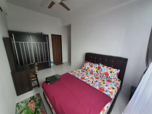 1 dormitorio con cama con colcha y almohadas rojas en Maz Stayhouse en Alor Setar