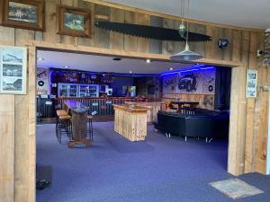 a restaurant with wooden walls and tables and a bar at National Park Alpine Lodge in National Park