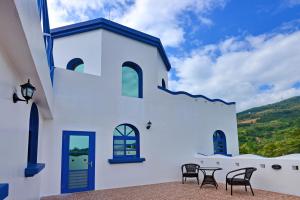 a white building with chairs and a table at The Forget Worry Villa in Taimali