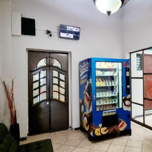 uma máquina de refrigerantes ao lado de uma porta num quarto em HOM Roma em Cidade do México