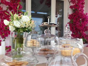 a table with three glass jars and vases with cookies at B&B Donnapasqua in Polignano a Mare