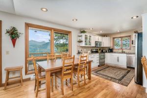 a kitchen with a table and chairs and a large window at Solitude Vacation Home at Windcliff home in Estes Park