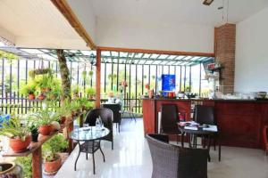 a restaurant with tables and chairs and plants at Platinum Place in Bangkok