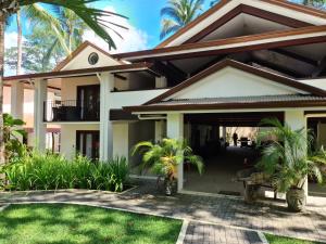a house with a courtyard and palm trees at Hona Beach Hotel in Dominical