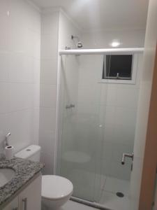 a bathroom with a shower with a toilet and a sink at Apartamento 500m Praia da Enseada Guarujá varanda e vaga de garagem in Guarujá