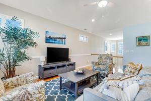 a living room with couches and a flat screen tv at The Tides --- 19967 Sandy Bottom in Rehoboth Beach