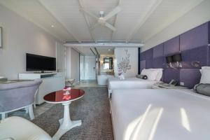 Una habitación de hotel con dos camas y un televisor. en Hua Chang Heritage Hotel, en Bangkok