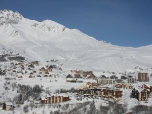 une ville couverte de neige devant une montagne dans l'établissement Appartement Saint-François-Longchamp, 2 pièces, 4 personnes - FR-1-635-27, à Saint-François-Longchamp