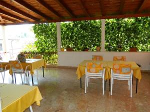 a dining room with yellow tables and chairs at Apartments and Rooms Darinka in Vrboska