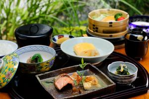 a table topped with bowls and plates of food at Ryokan Asukasou at the entrancne of Nara park in Nara