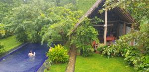 a man in a swimming pool next to a house at il Frangipane in Sigiriya