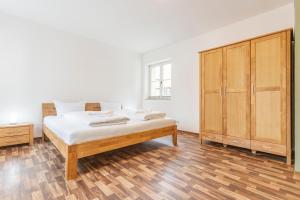 una camera con letto e armadio in legno di WR Grüne Ferienwohnung in der alten Apotheke a Wernigerode