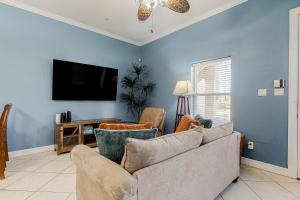 a living room with a couch and a flat screen tv at Saturn Serenity & Condo in South Padre Island