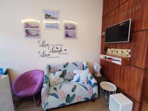 uma sala de estar com um sofá e uma televisão em Acrige Apartelle 2-4 pax Queen @ heart of Bogo City em Banban