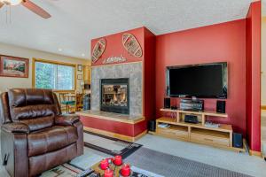 a living room with a fireplace and a television at Alltitude Chalet in Government Camp