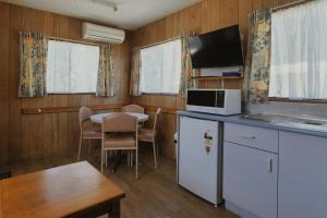 a kitchen and dining room with a table and a microwave at Woodmans Hill Motel in Ballarat