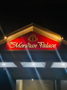 a neon sign for a marilyn palupe restaurant at Hotel Meridian Palace in Kannur