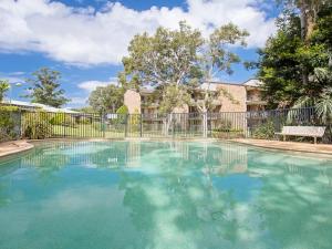 a swimming pool in front of a fence at Bay Parklands 23 located at Little Beach with air con pool and tennis court in Shoal Bay