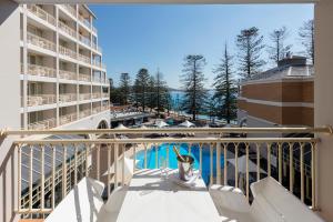 einen Blick auf den Pool vom Balkon eines Gebäudes in der Unterkunft Crowne Plaza Terrigal Pacific, an IHG Hotel in Terrigal