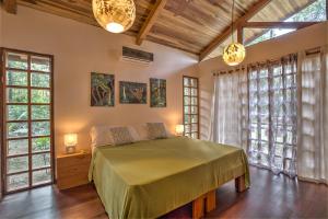 a bedroom with a bed in a room with windows at Las Palomas Villas in Cocles