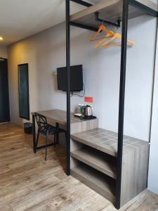 a room with a desk and a table with a tv at See Foo Hotel in Bidur