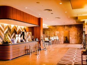 a restaurant with a counter and chairs in a lobby at Hachinohe Plaza Hotel in Hachinohe