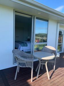 a patio with a table and chairs on a balcony at Kinloch Lake & Golf Views in Kinloch