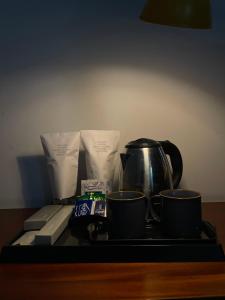 a tray with two cups and a tea kettle at The Reach Hotel in Cochin