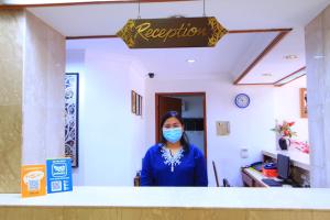 a woman wearing a mask in a room at Telang Usan Hotel Kuching in Kuching