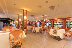 a restaurant with white tables and chairs and tablesearcher at Telang Usan Hotel Kuching in Kuching