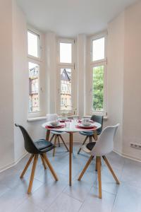ヴェルニゲローデにあるWR Rote Ferienwohnung in der alten Apothekeのテーブルと椅子2脚のあるダイニングルーム
