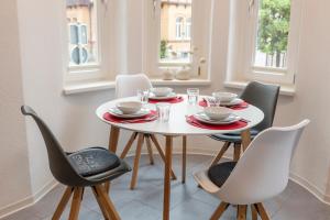 ヴェルニゲローデにあるWR Rote Ferienwohnung in der alten Apothekeの白いテーブルと椅子のあるダイニングルーム +1枚の写真
