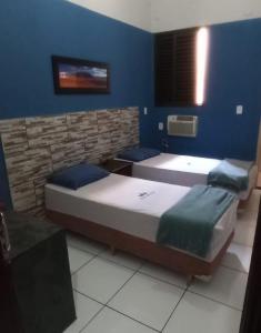 2 camas en una habitación con paredes azules en Hotel Vila Real, en Araçatuba