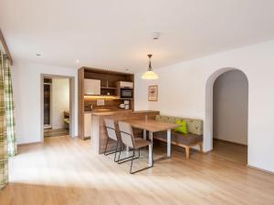 a kitchen and living room with a wooden table and chairs at Apartment in Wald near Zillertal Ski Slopes in Wald im Pinzgau