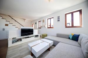a living room with a couch and a tv at Apartman Murter in Murter