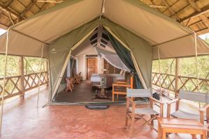 a tent with chairs and tables inside of it at Twiga Safari Lodge in Murchison Falls National Park