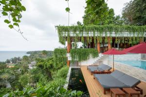 a resort with a swimming pool and chairs and a swimming poolvisorvisor at Rachawadee Surin Beach-SHA Extra Plus in Surin Beach