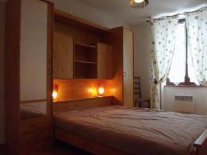 1 dormitorio con 1 cama con cabecero de madera en Gîte Neuillay-les-Bois, 3 pièces, 5 personnes - FR-1-591-104, en Neuillay-les-Bois
