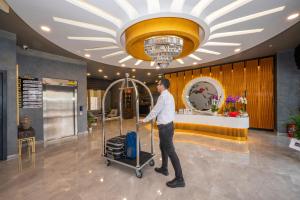 Ein Mann schiebt einen Gepäckwagen in einer Lobby. in der Unterkunft Seyithan Palace Spa Hotel in Istanbul + 37 Fotos