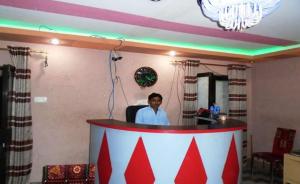 Un homme debout derrière un podium dans une pièce dans l'établissement Vip Guest House, à Umarkot