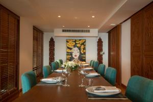 a long dining room with a long table and blue chairs at Rachawadee Surin Beach-SHA Extra Plus in Surin Beach