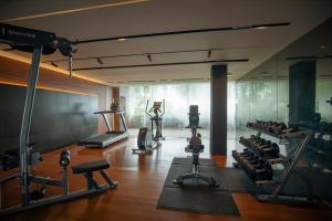 a gym with several treadmills and exercise equipment at Rachawadee Surin Beach-SHA Extra Plus in Surin Beach