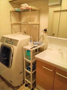 a bathroom with a sink and a washing machine at AnBeeeNa in Akita