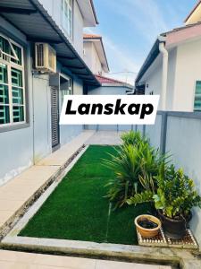 a lawn in front of a house with the words landscaping at No 11 Nazirin Homestay Tmn Desa Manjung Lumut in Lumut