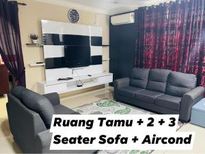 a living room with a couch and a tv at No 11 Nazirin Homestay Tmn Desa Manjung Lumut in Lumut