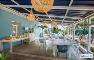 un patio con mesas, sillas y luces en Bleu de Toi Boutique Guesthouse, en Pereybere
