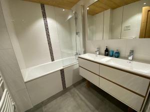 a white bathroom with a sink and a shower at Chalet Azalée, Montriond, Morzine, Avoriaz in Montriond +106 photos